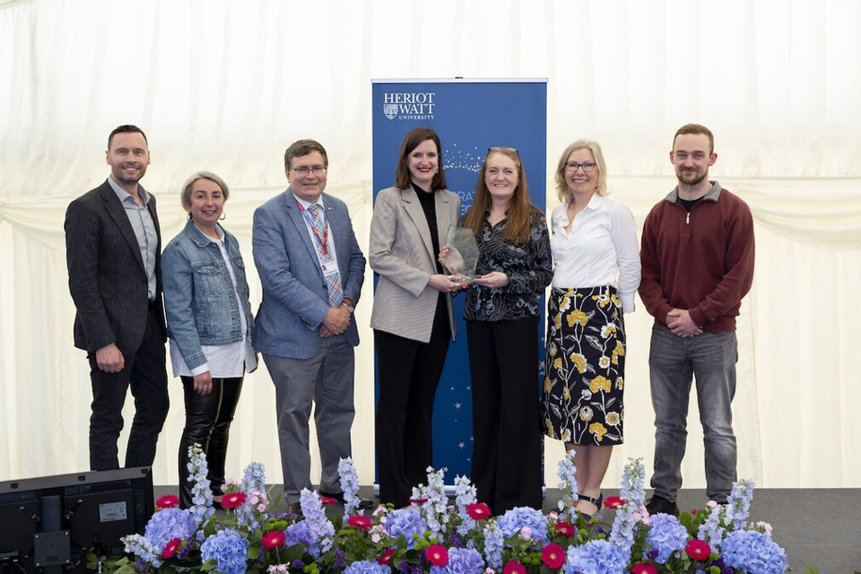 The Lothian Lugs team receiving their award from Principal Richard Williams Seven individuals smiling as they receive an award.