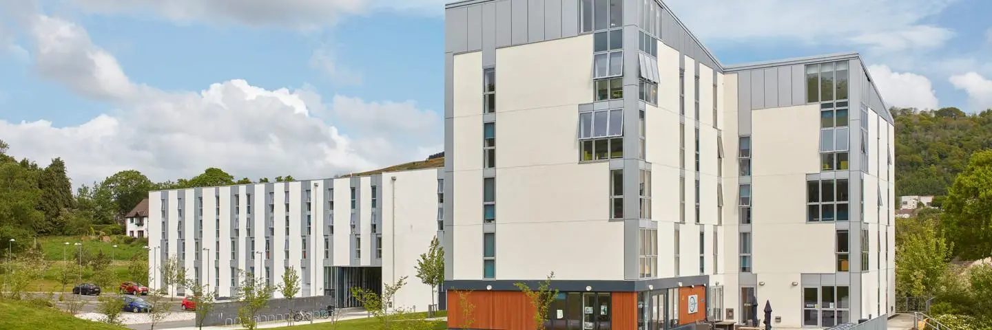 The Jean Muir Student Village, five storey white buildings surrounded by grass and trees