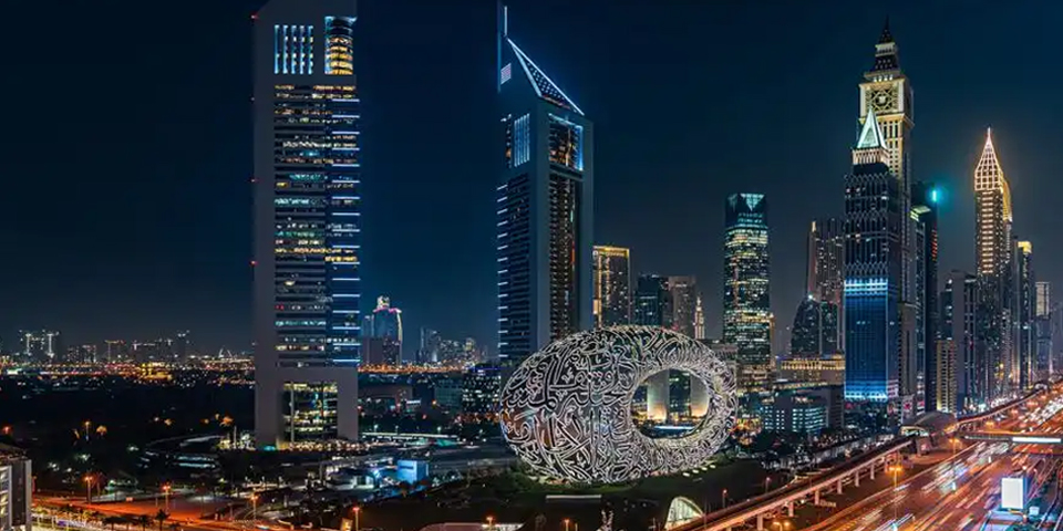 Dubai skyline at night featuring the futuristic Museum of the Future and high-rise buildings.