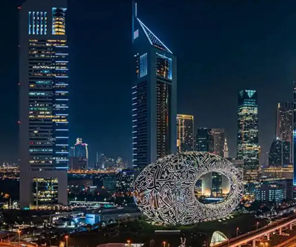 Dubai skyline at night featuring the futuristic Museum of the Future and high-rise buildings.