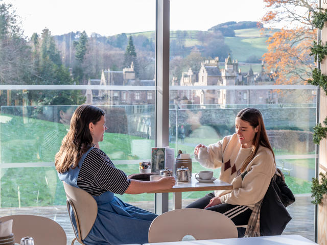 Two people sitting in a cafe drinking tea.