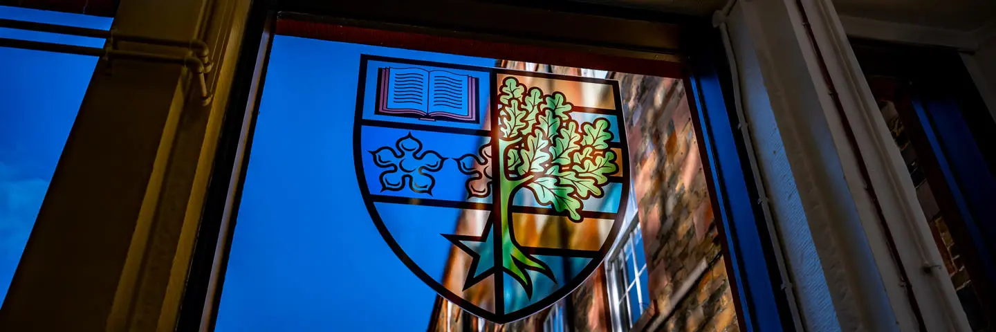 The Heriot-Watt University badge in a stained glass window.