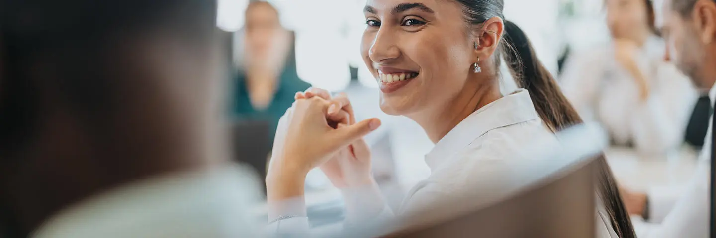 A smiling individual in a meeting