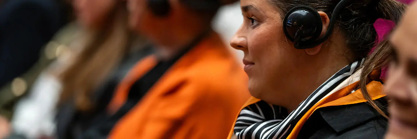 A spectator listens to translation at event