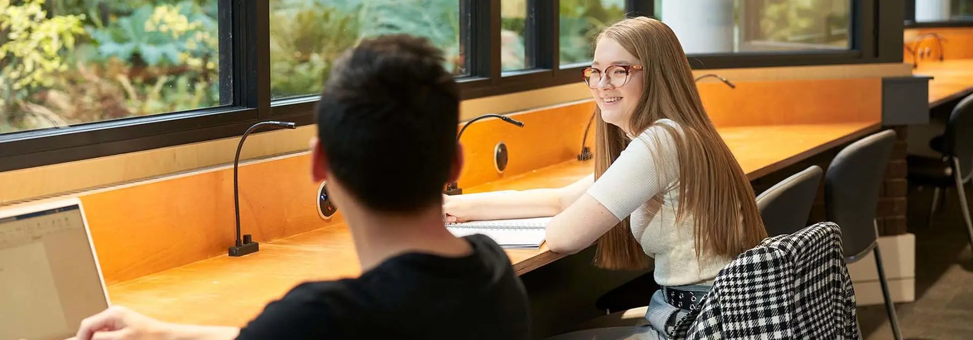 Two students smiling as they work