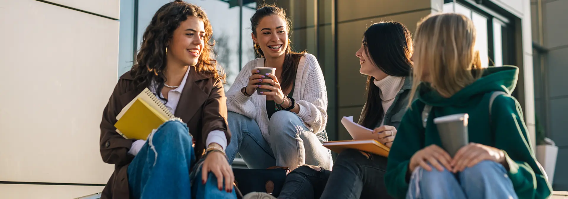 Four students sitting together drinking coffee.