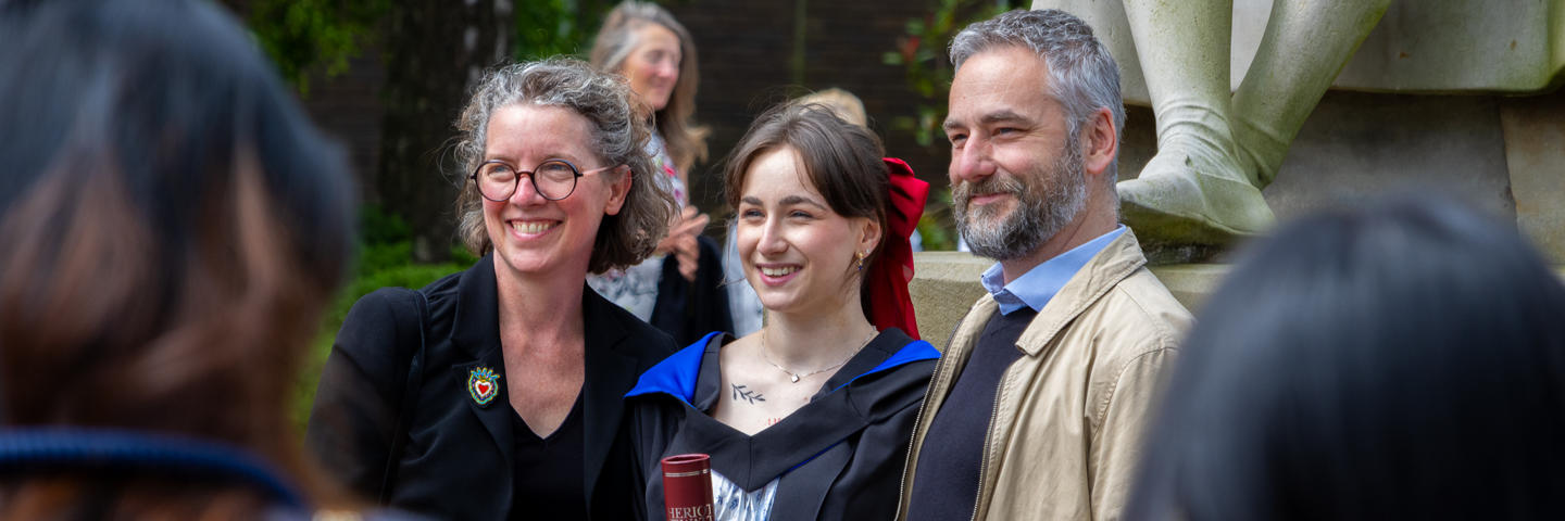 A graduate from Edinburgh campus poses for photos with their family.