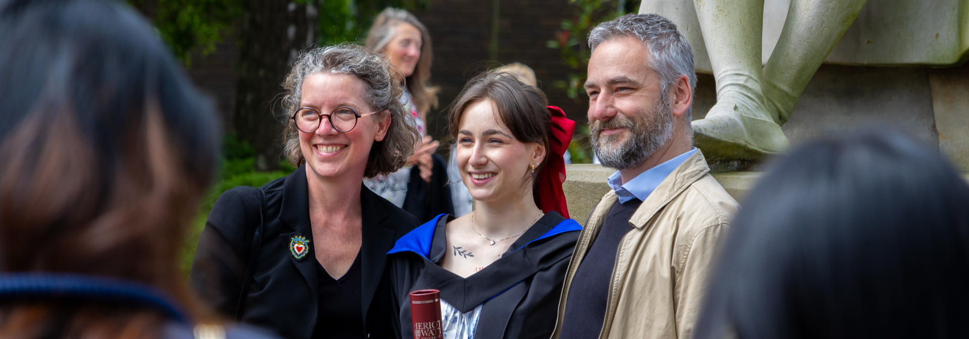 A graduate from Edinburgh campus poses for photos with their family.