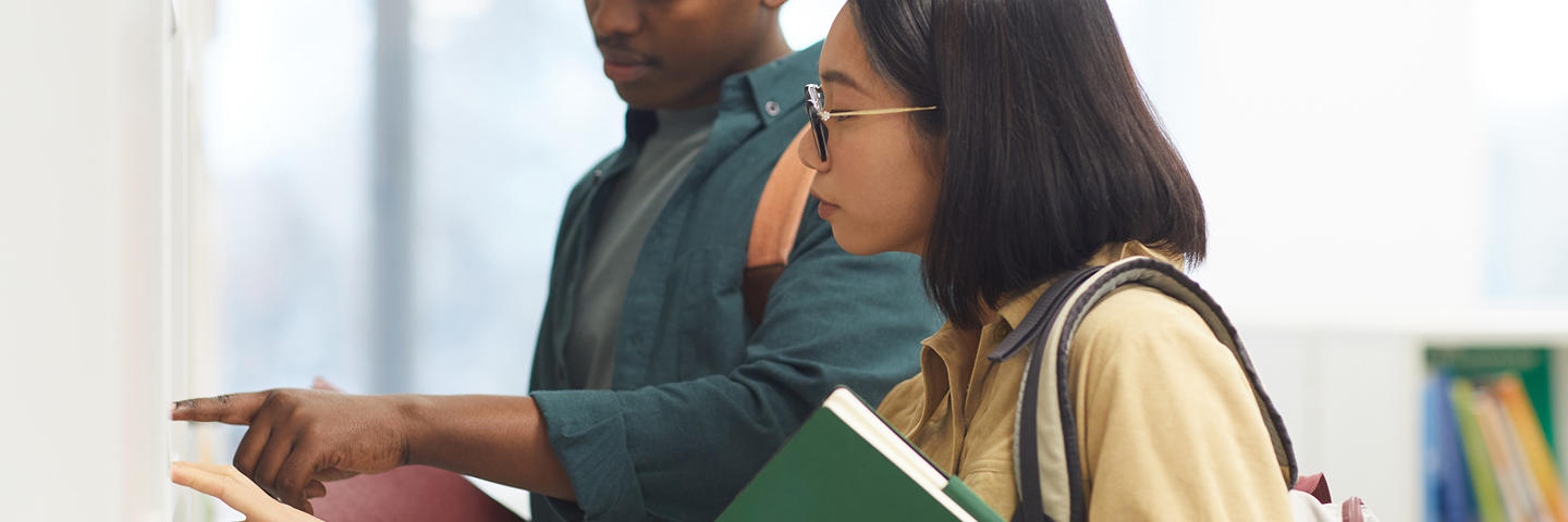 Two students looking at a board together.