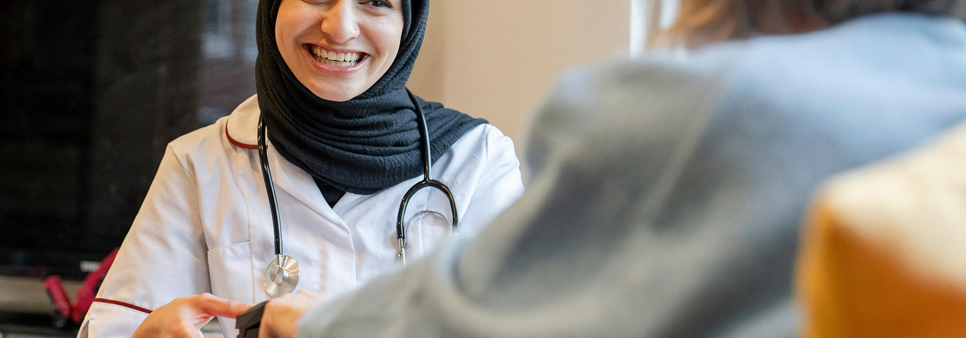 Health practitioner with a patient using equipment.