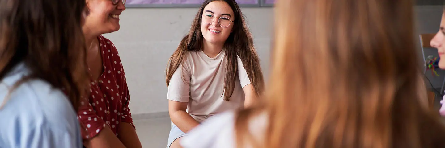 Students sit in a circle in discussion.