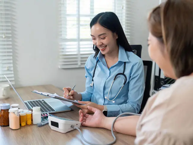 Doctor takes a patient's blood pressure.