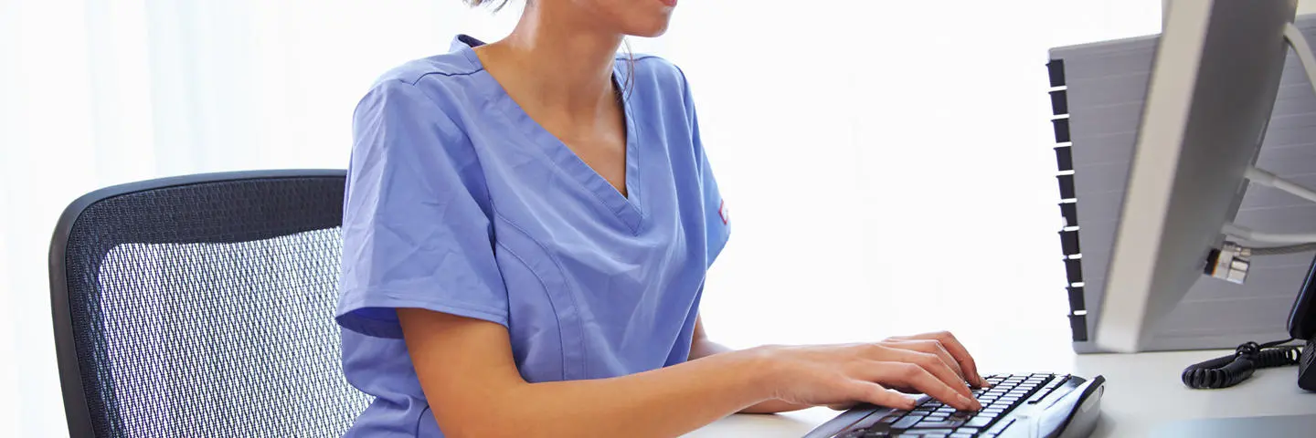 A doctor working at a computer.