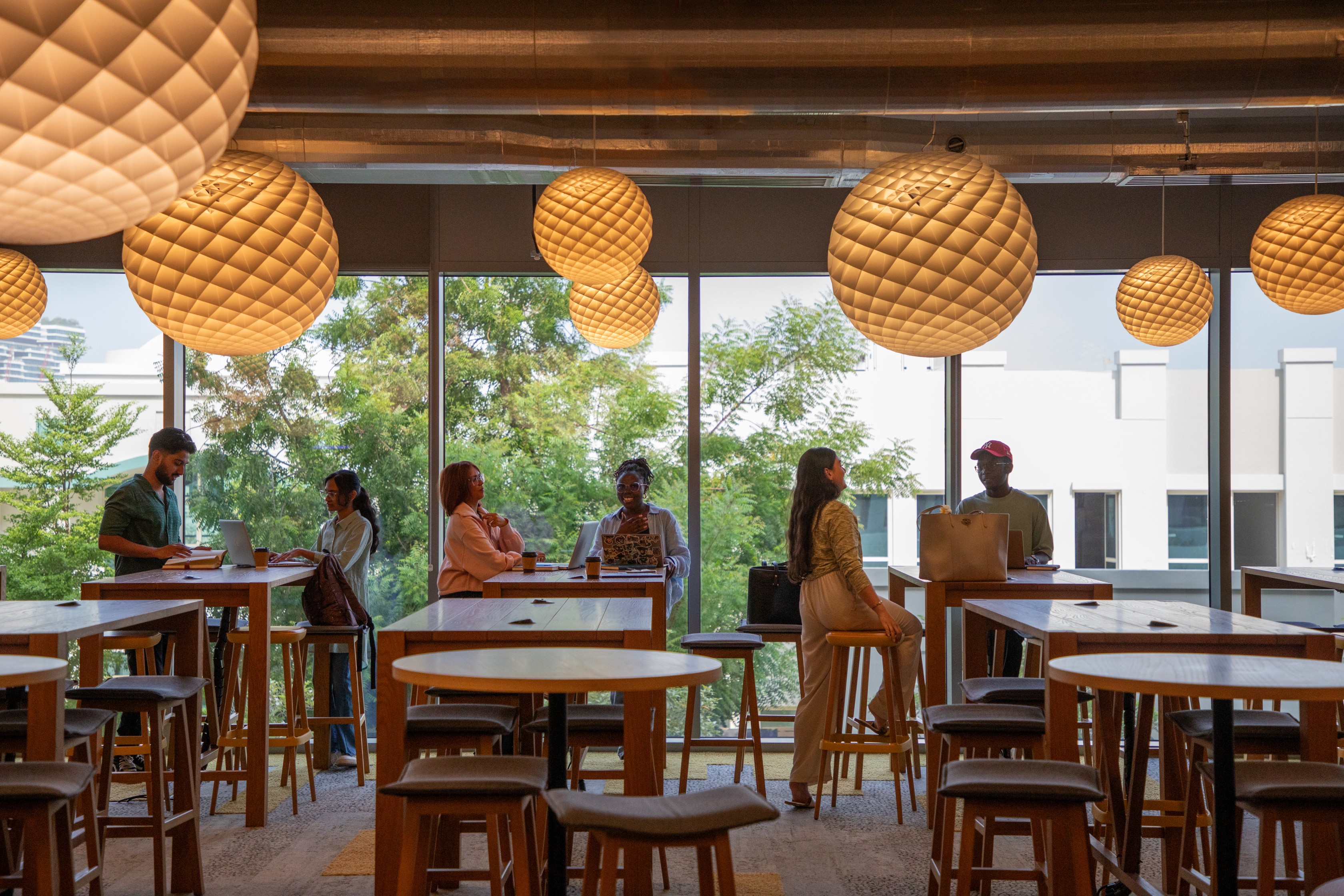 Student sitting and socialising on tall tables and stools
