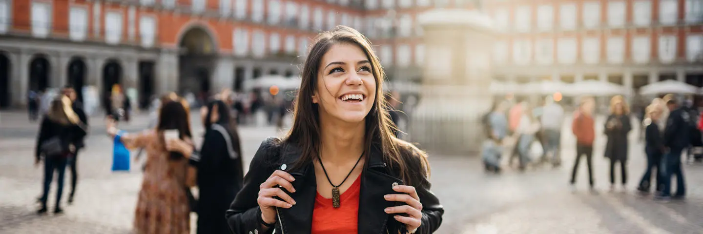A student walking through a European city square on an exchange.