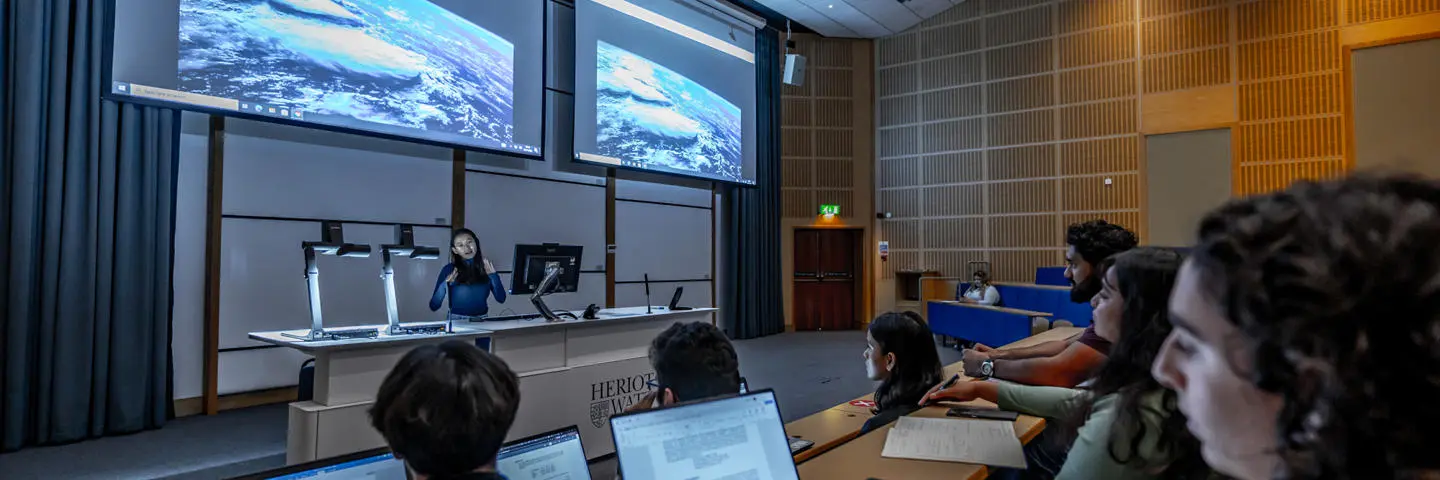 Students sitting in attendance in a lecture theatre with computers.