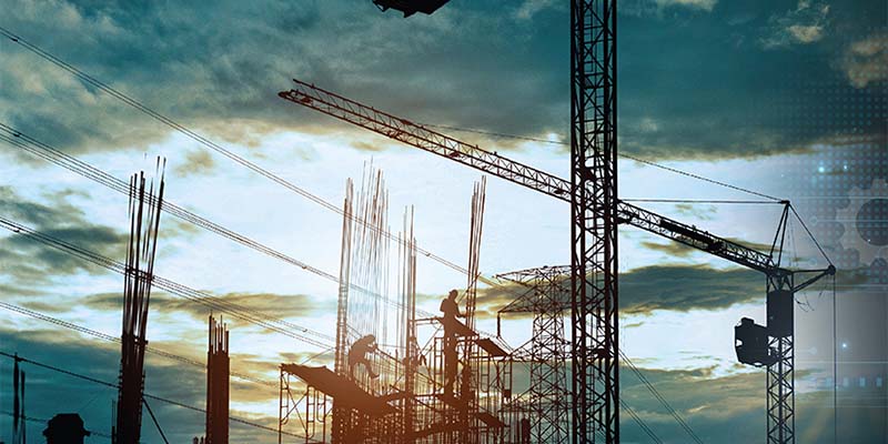 Vertical pillars being constructed on a building site with scaffold and crane.