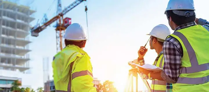 Construction managers communicate with a crane operator using a handheld radio