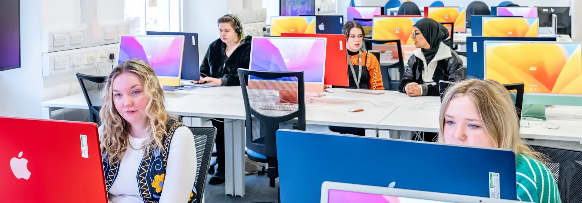 Students sit in a computer lab.