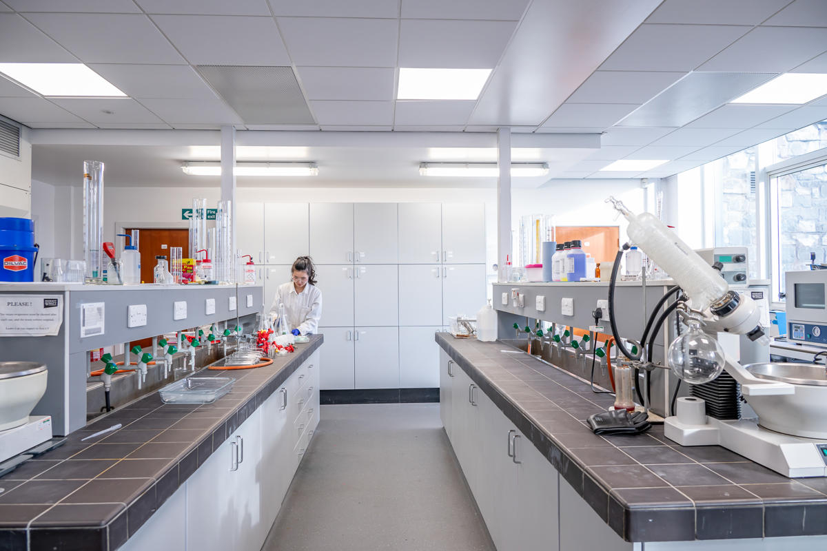 A chemical laboratory with multiple cupboards and equipment on display.