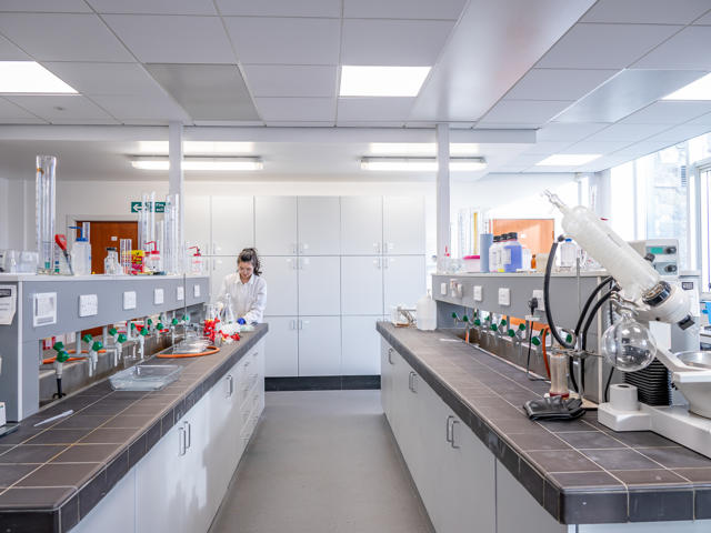 A chemical laboratory with multiple cupboards and equipment on display.