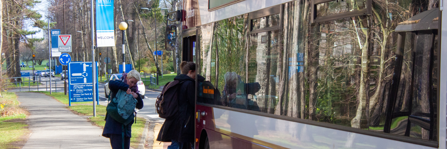 Picture of two individuals getting onto a bus.