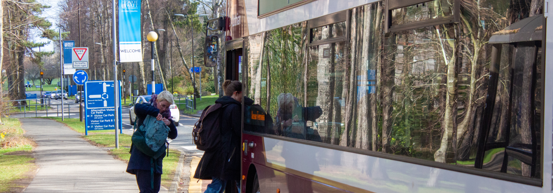 Picture of two individuals getting onto a bus.