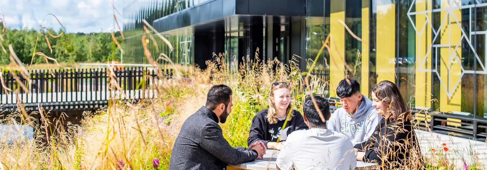 Students sit chatting outside the National Robotarium