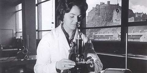 Chemistry student in lab with Edinburgh Castle in backdrop