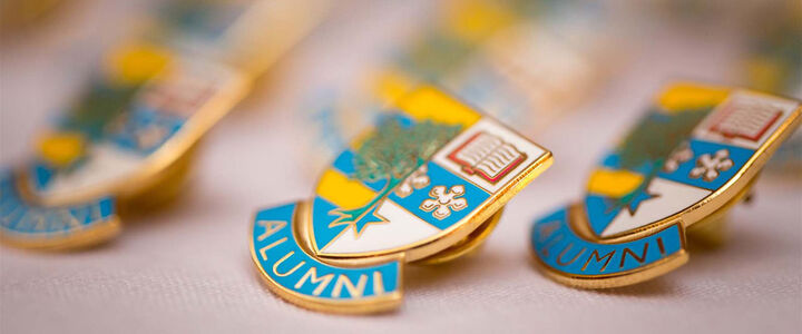 Heriot-Watt Alumni pins on a white tablecloth