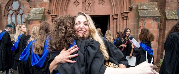 Two graduands of the School of Textiles and Design embrace after the ceremony