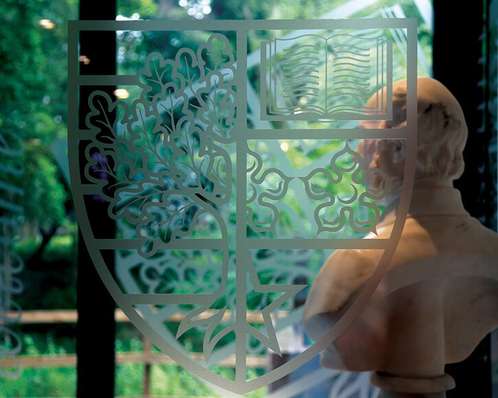 Bust of James Watt viewed through a glass door with Heriot-Watt crest imprint