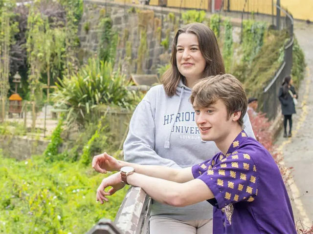 Two students relax and watch the Water of Leith as it flows through the Dean Village.