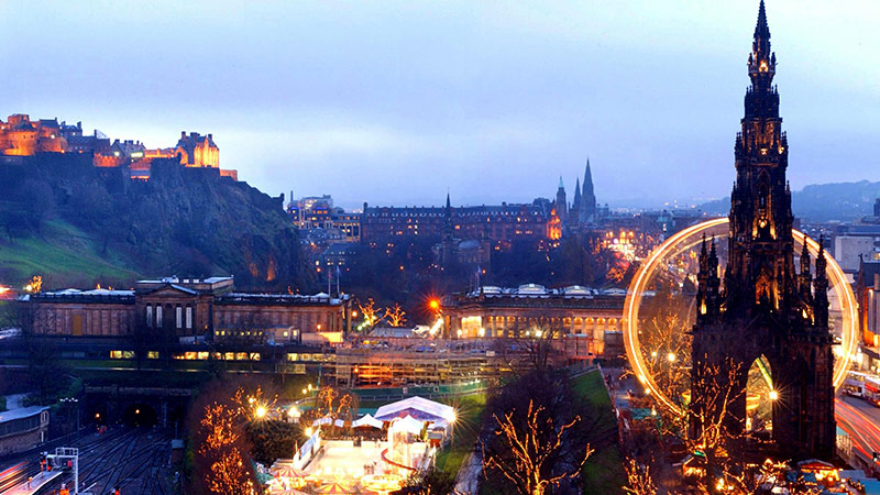 Edinburgh city skyline at dusk with 'Winter Wonderland' entertainments in progress