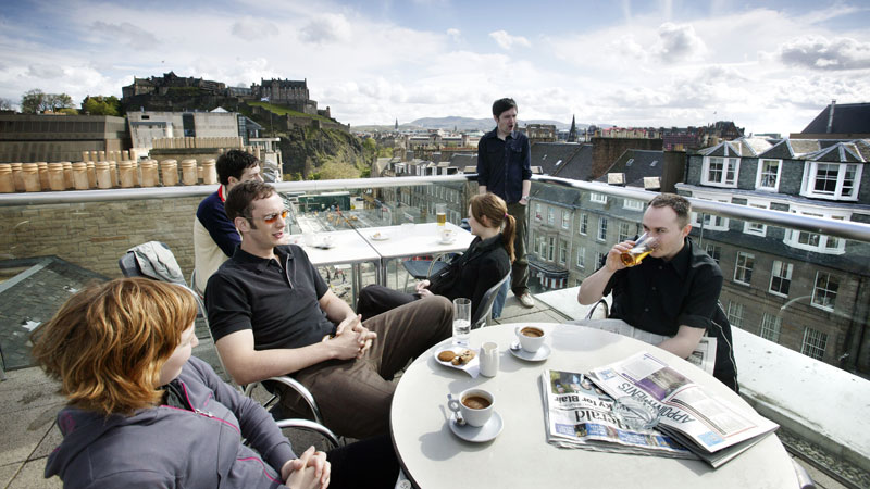 Diners on rooftop terrace overlooking Edinburgh Castle