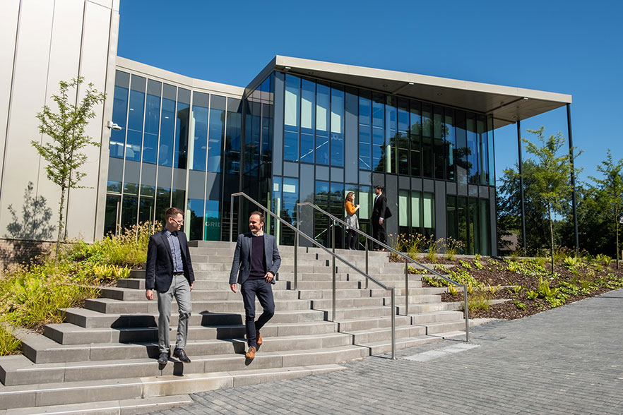 Office workers on steps of glass-fronted building