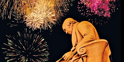 The James Watt statue with fireworks exploding overhead at night