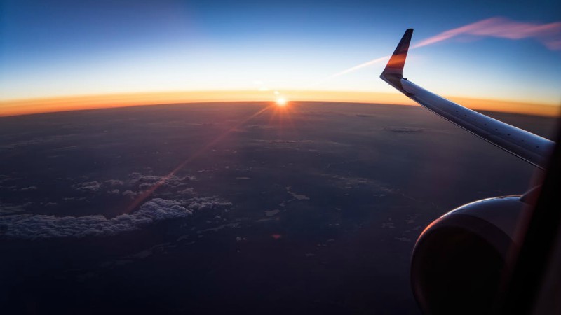 Plane flying over sunset