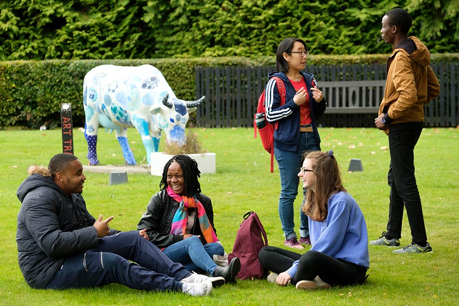 Group of students on the grass opposite the main entrance, Edinburgh Campus