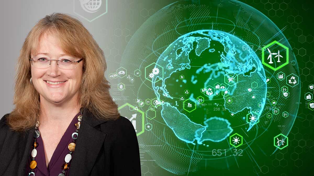 Professor Susan Krumdieck beside a hologram of the globe overlaid with icons representing recycling, wind farms, solar energy etc
