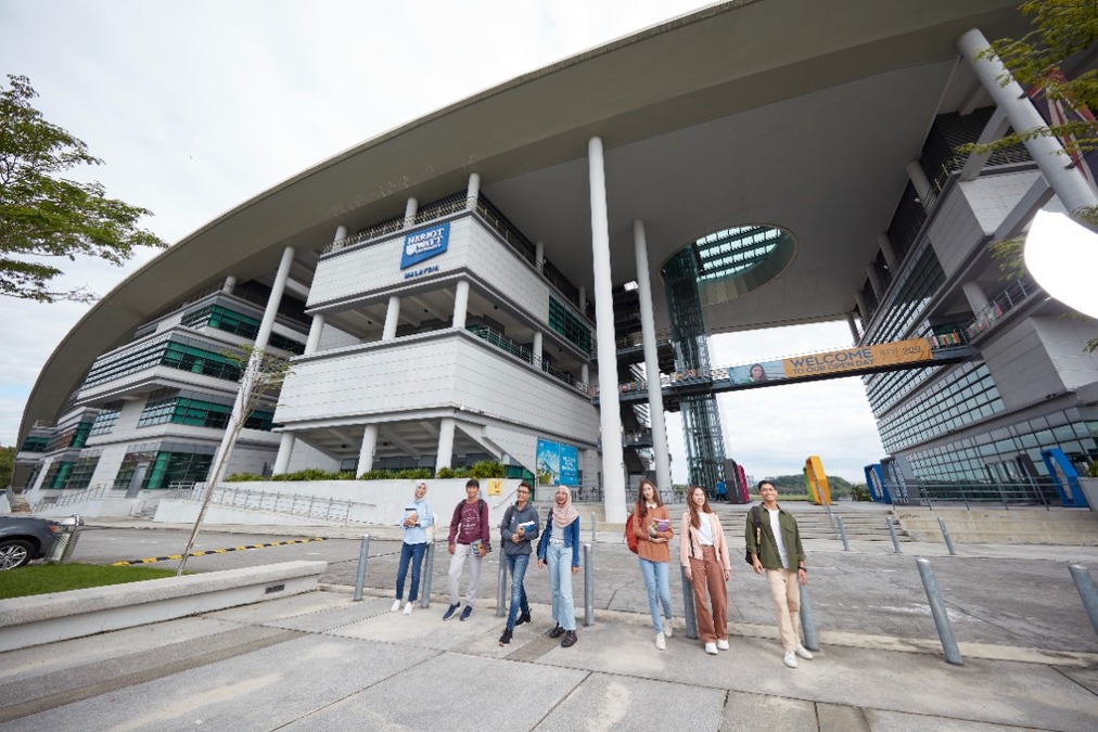 Smiling students walking outside a building on campus