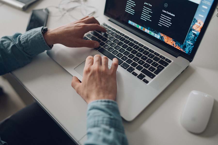 Man's hands using a laptop keyboard