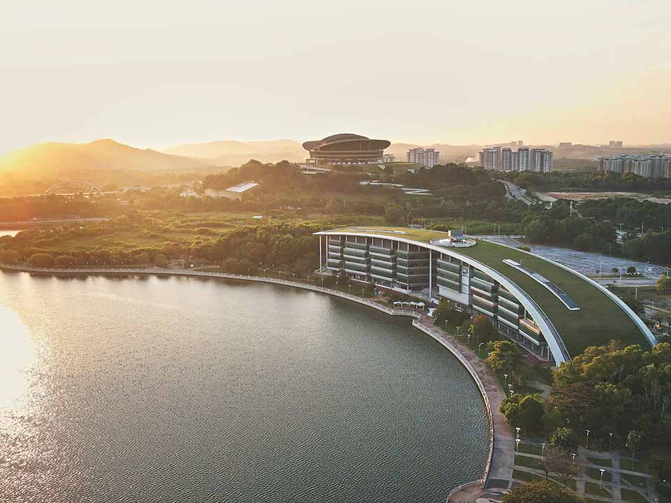 Aerial view of the Malaysia Campus building at sunset with the lake in the foreground
