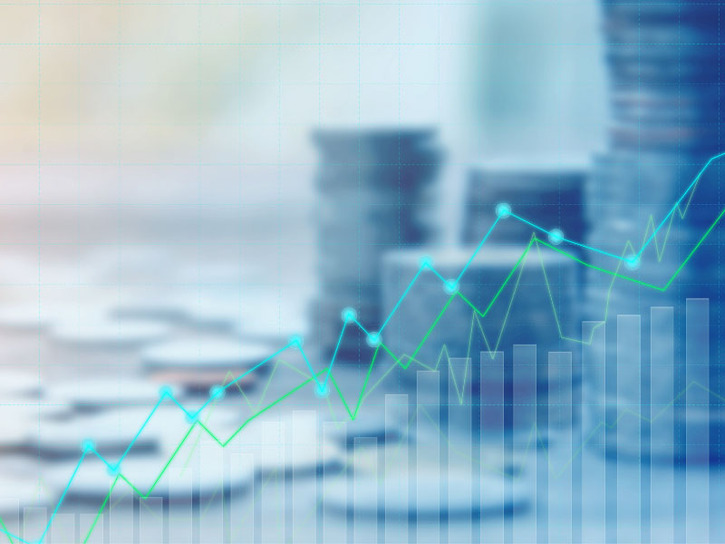 Stacks of coins behind a partially opaque overlay of a bar chart indicating growth