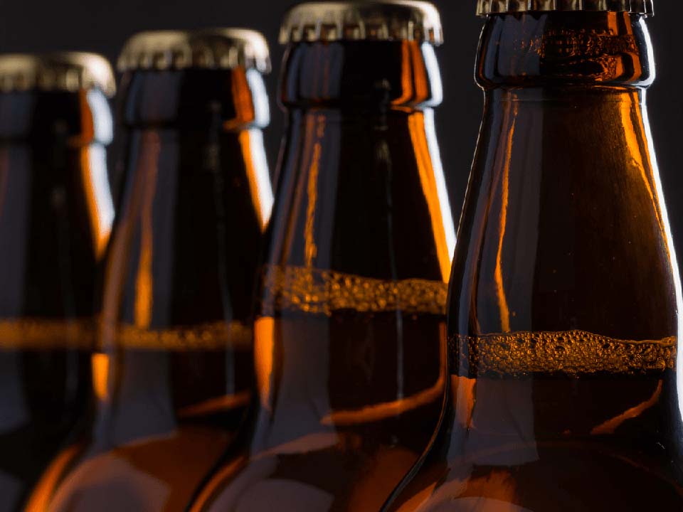 Four brown beer bottles in a row