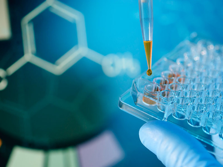 Lab technician injecting liquid into a microtiter plate