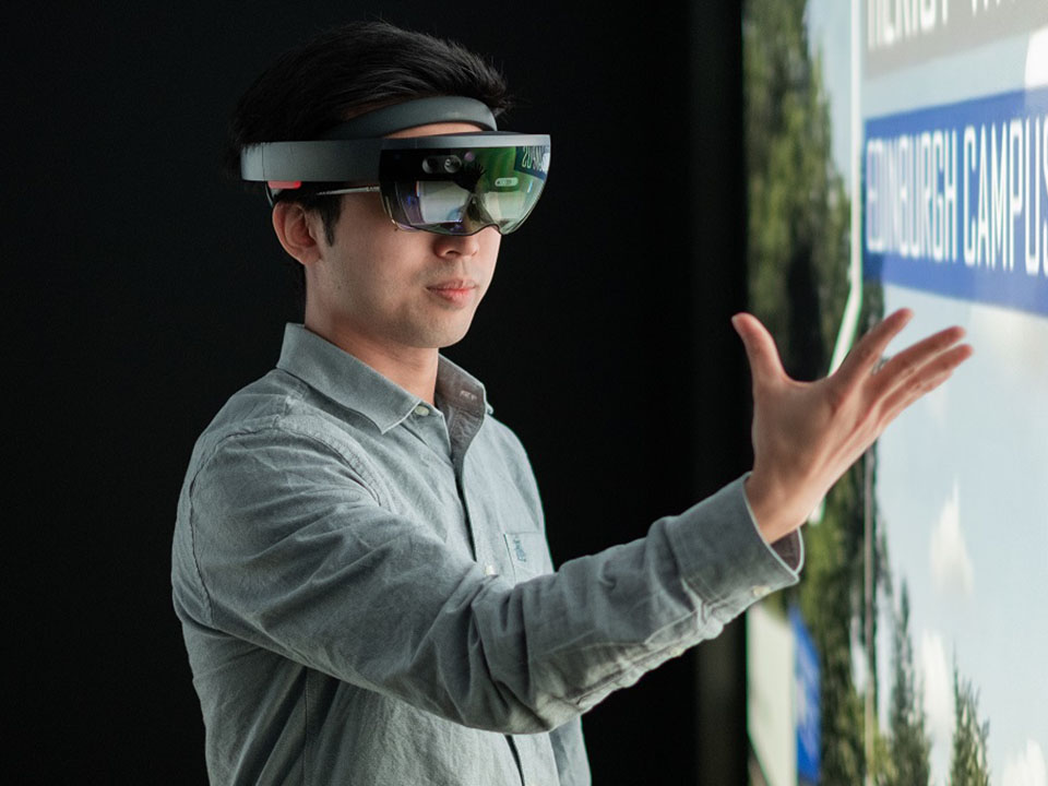 Male student wearing virtual reality headset in the Imagineering Suite at the Grid Building