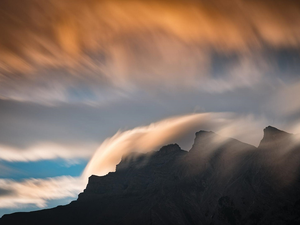 long exposure of clouds rolling over mountains