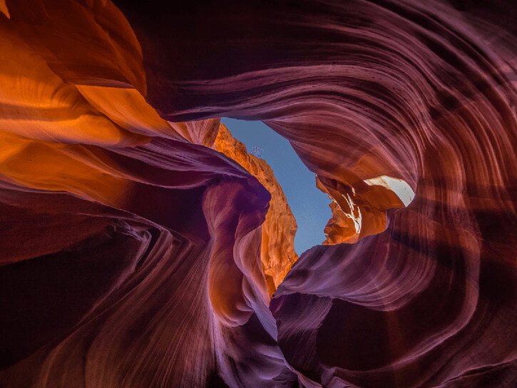 upwards shot of red canyon rocks breaking into sky in centre