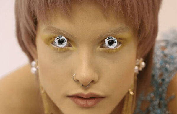 Close up of model's face, wearing beige full body makeup with eyes painted over